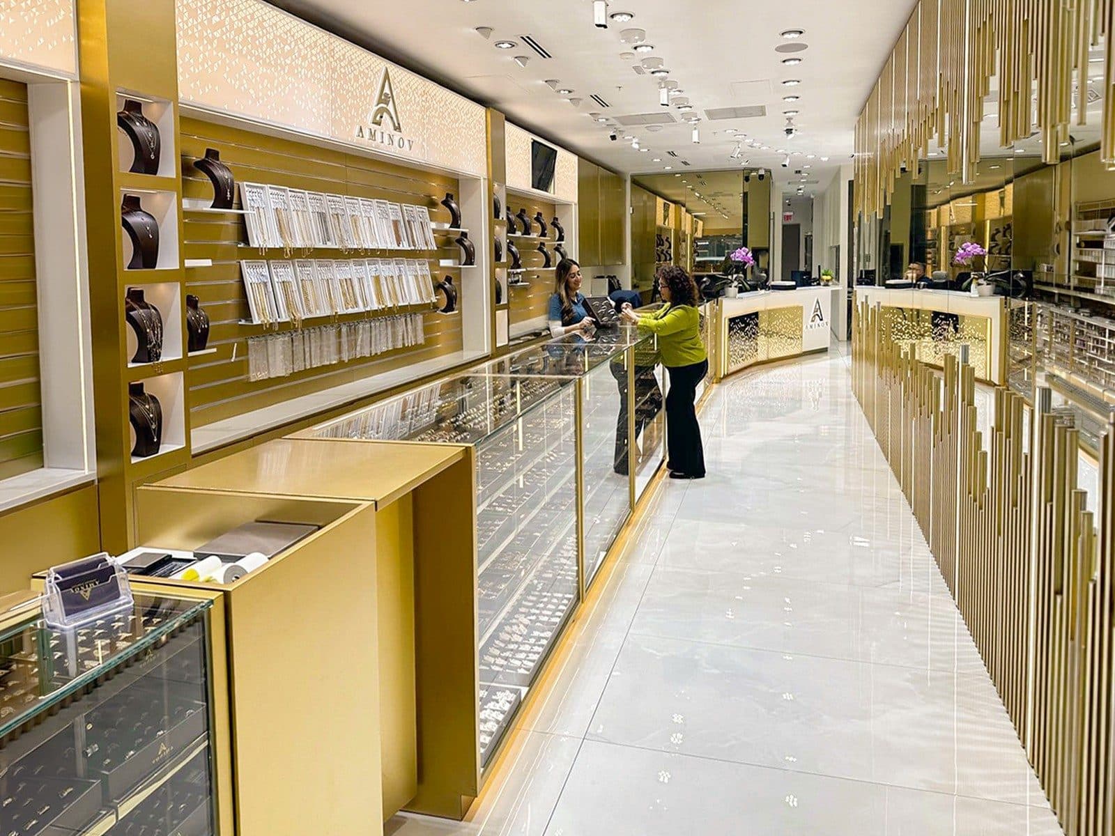The long jewelry counter and necklace wall in the Aminov Jewelry showroom, looking toward the back counter